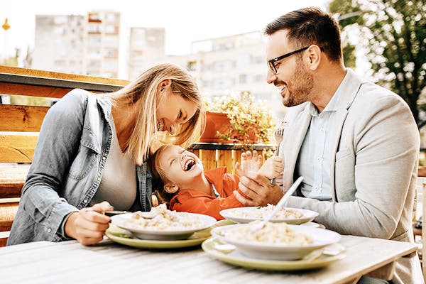 Happy family enjoying pasta in a restaurant.