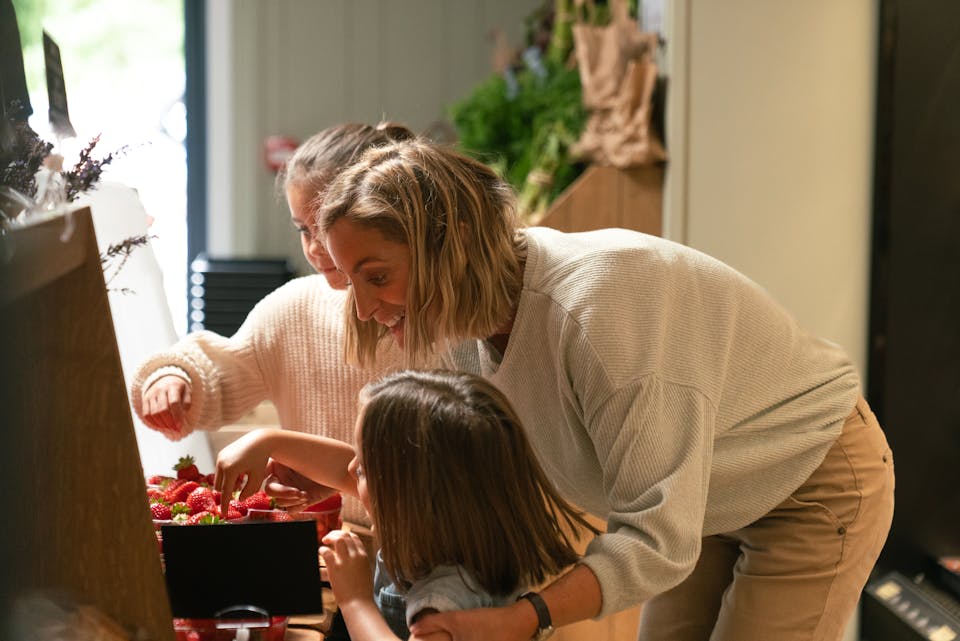 A women with her children taking a break eating strawberries while waiting for her electric car to charge at a Osprey EV charger.