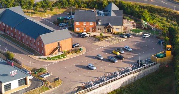 Aerial shot of Paisley Pear restaurant and hotel with 8-charger rapid charging hub in carpark.
