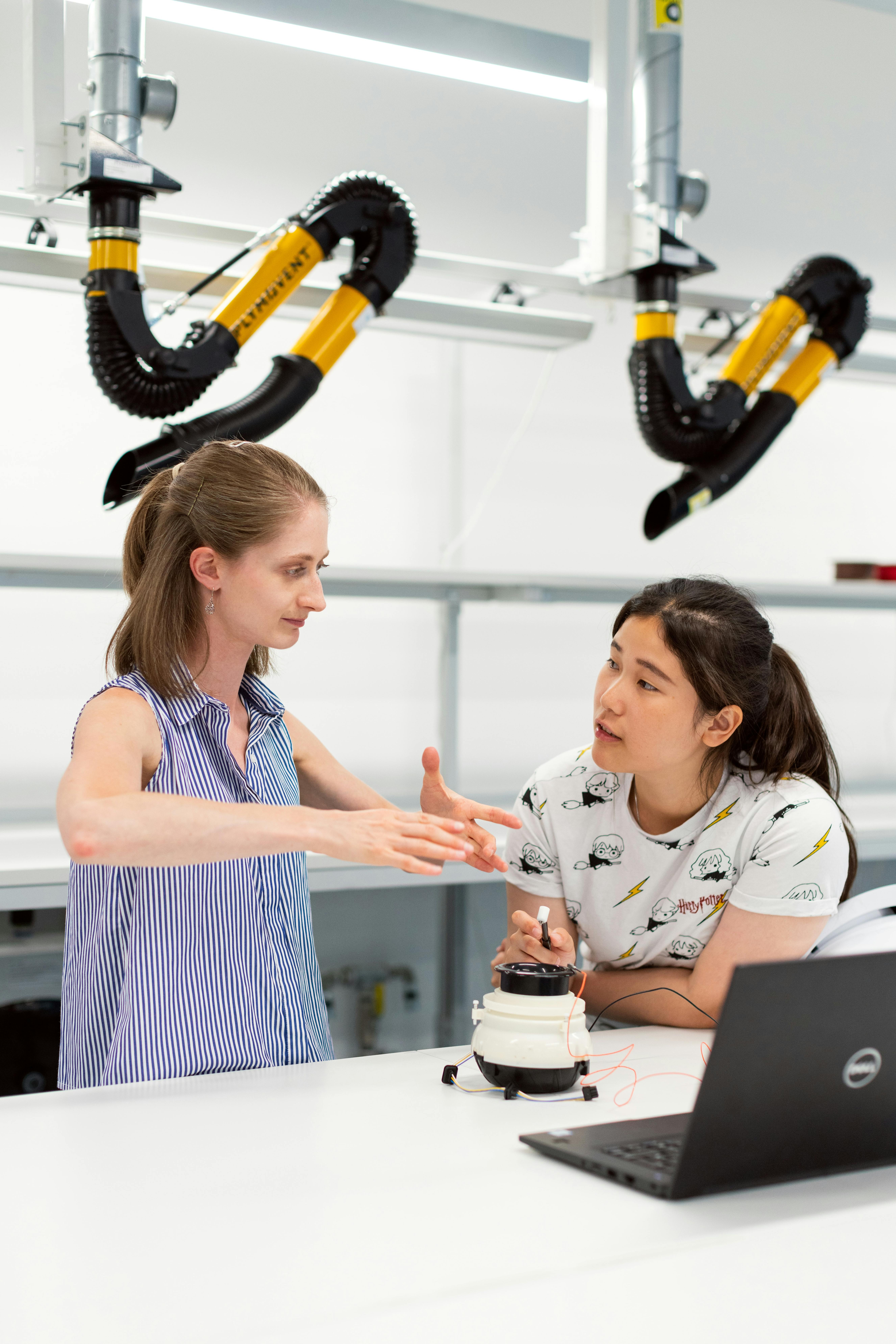 Female noise and vibration engineer oversees student testing vibrations through software