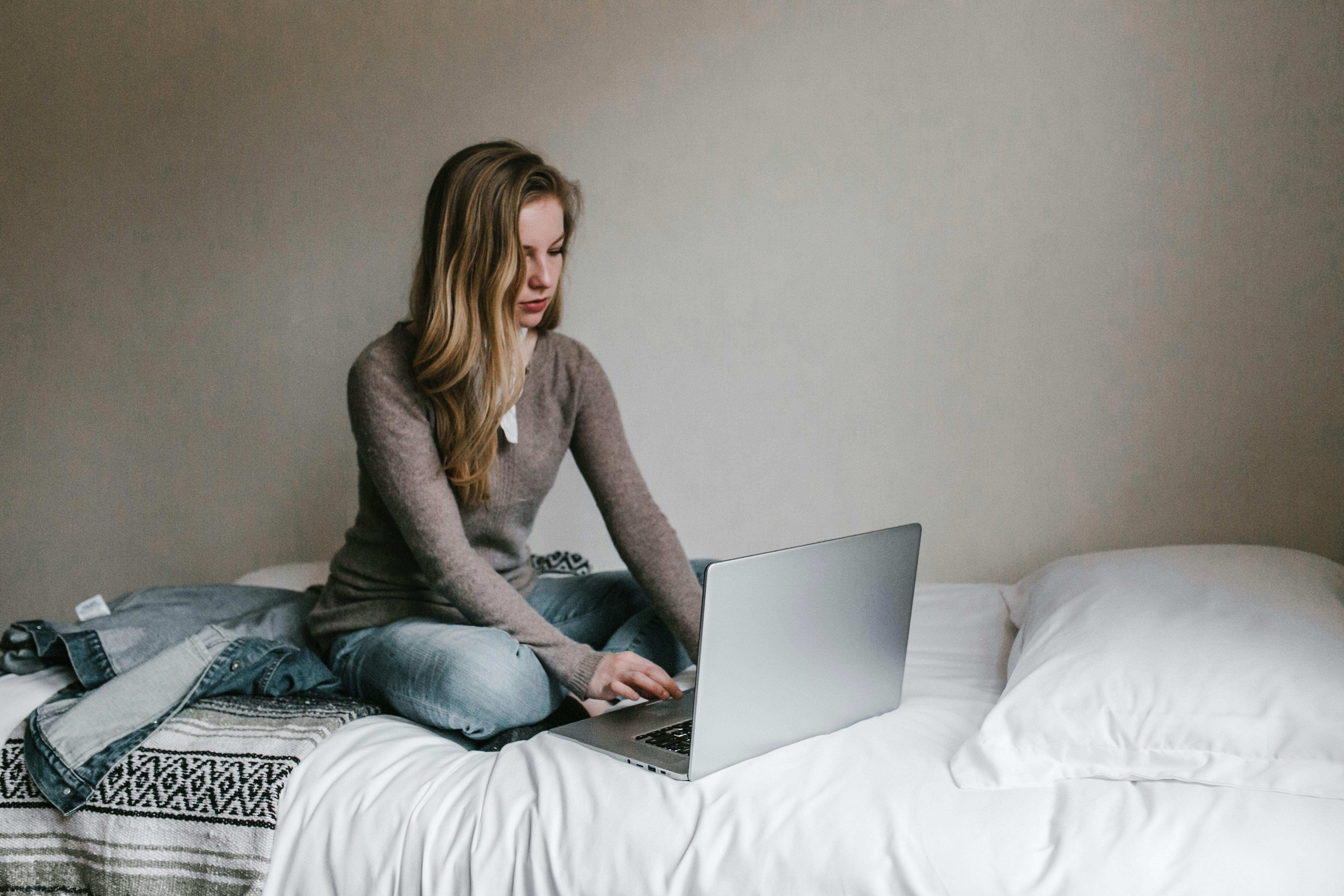 Person working online from the comfort of their bed.