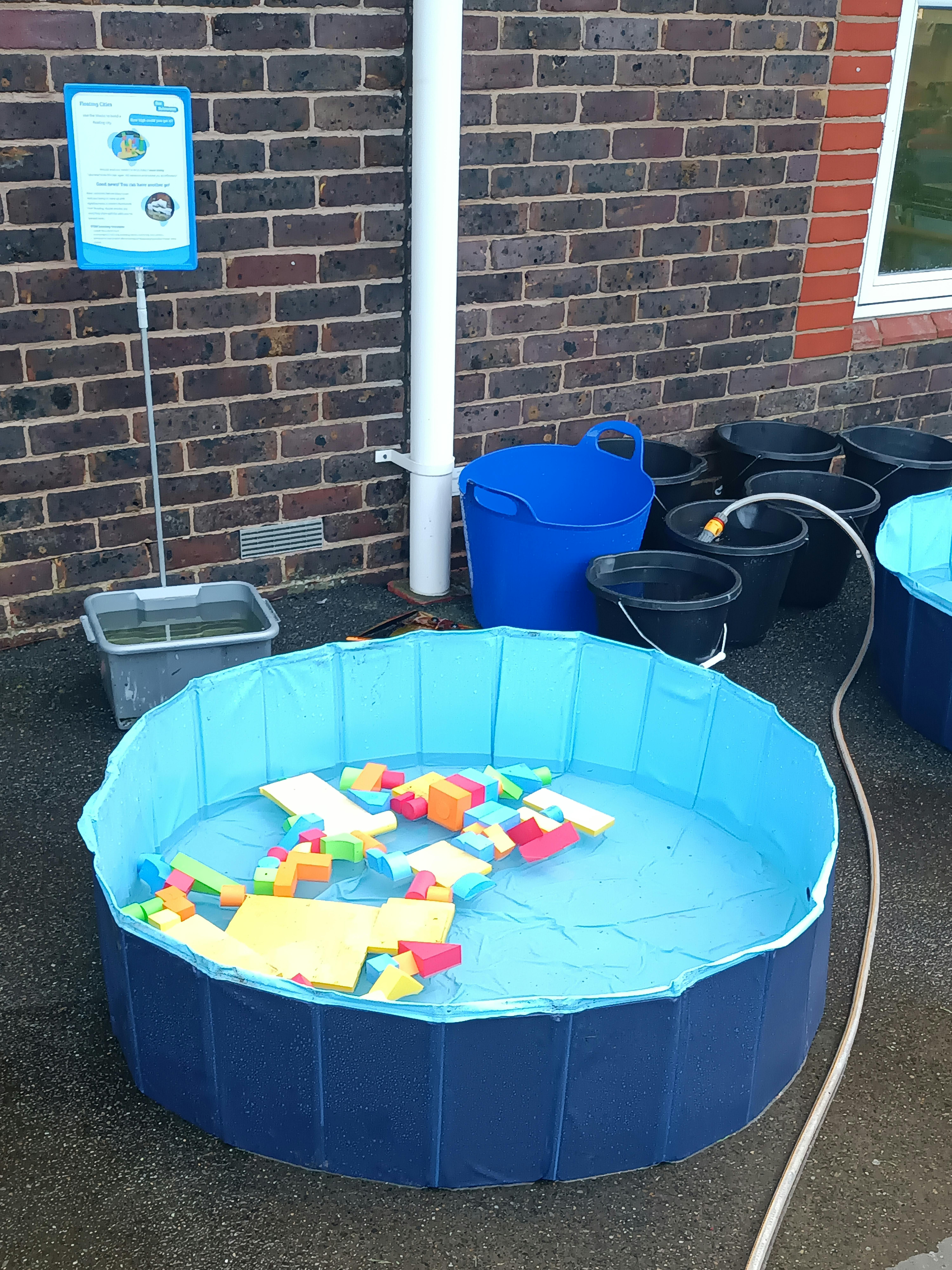 Paddling pool with coloured bricks floating in it