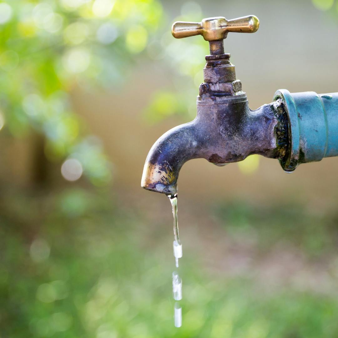 An outdoor water tap dripping