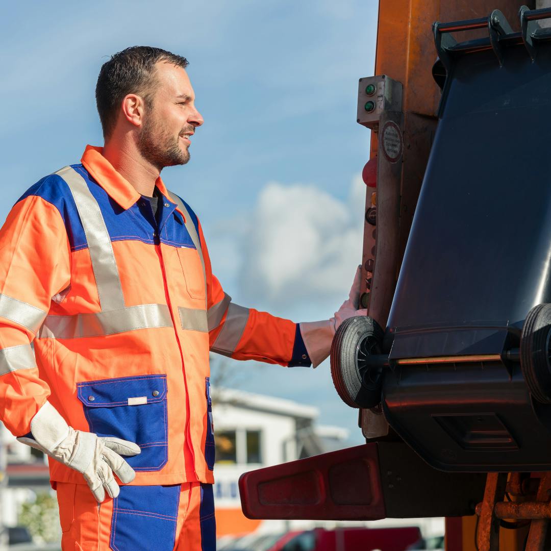 A binman emptying a wheelie bin into the lorry