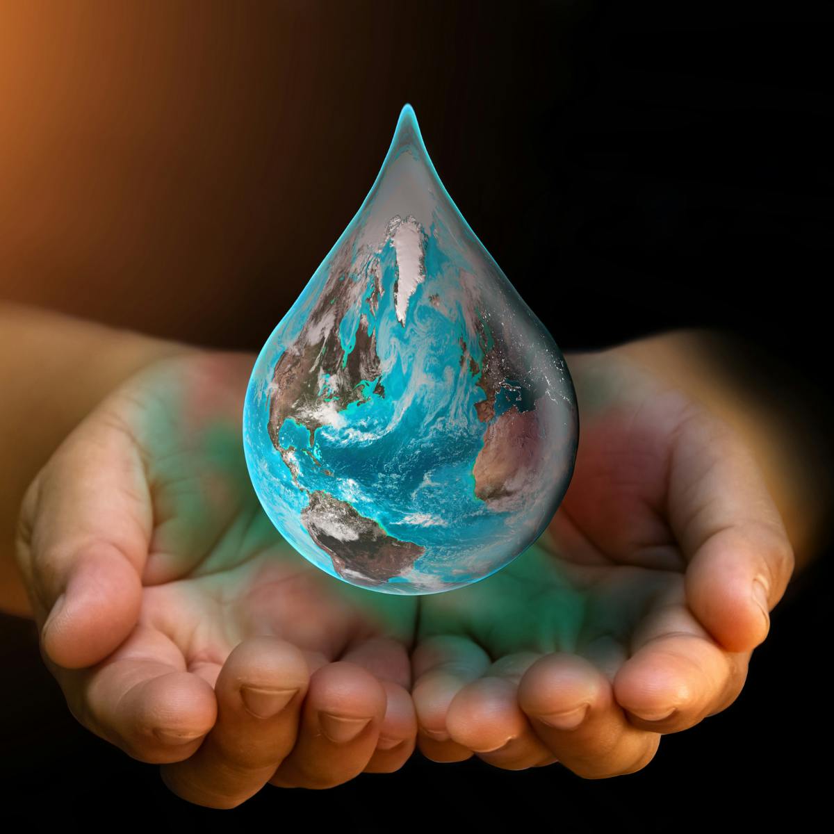 Hands holding water drop that has the earth's reflection
