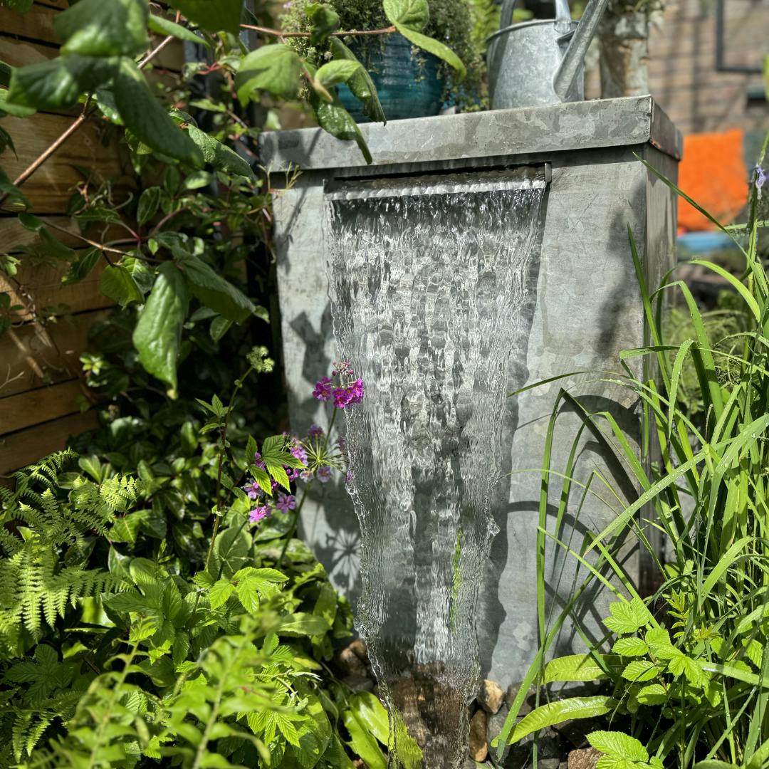 Galvanised water tank releasing water 