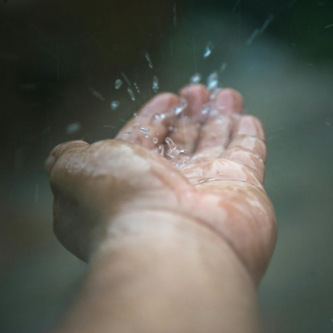 a hand catching raindrops