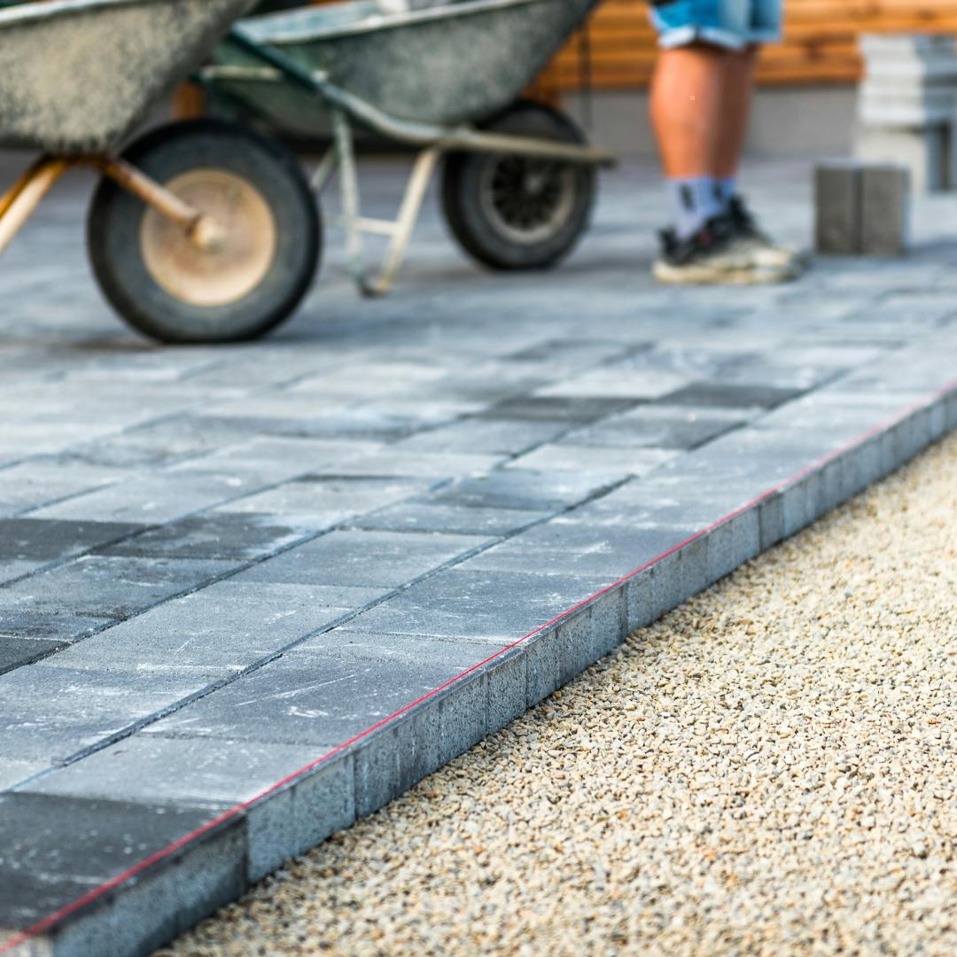 Concrete driveway with a wheelbarrow in the background