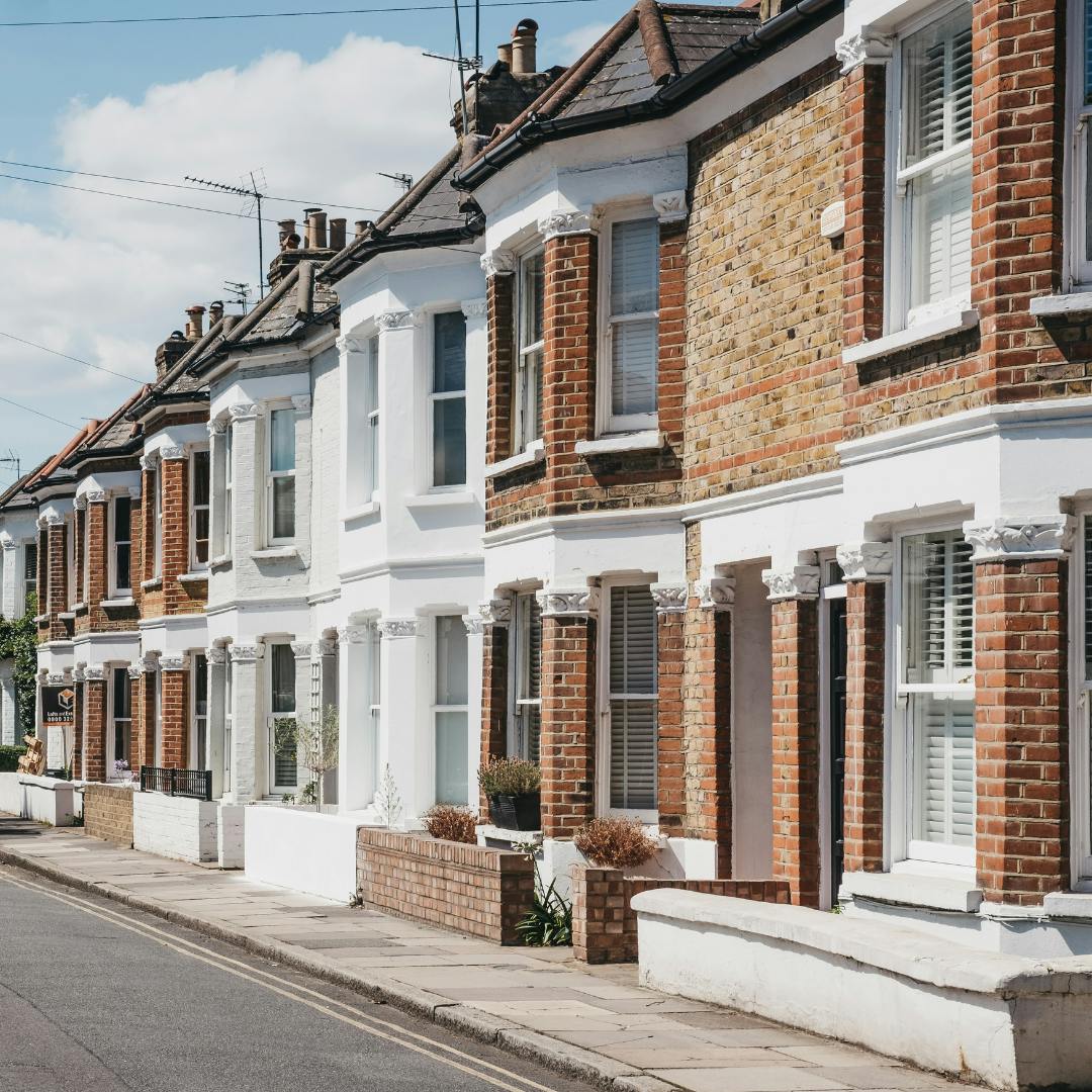 A row of terraced houses with no front garden just concrete