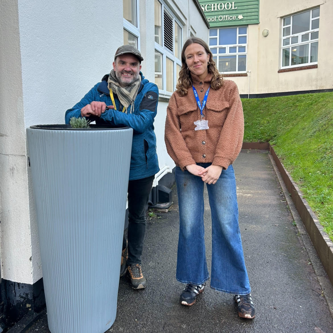 Laura and Nick standing next to a rainwater planter