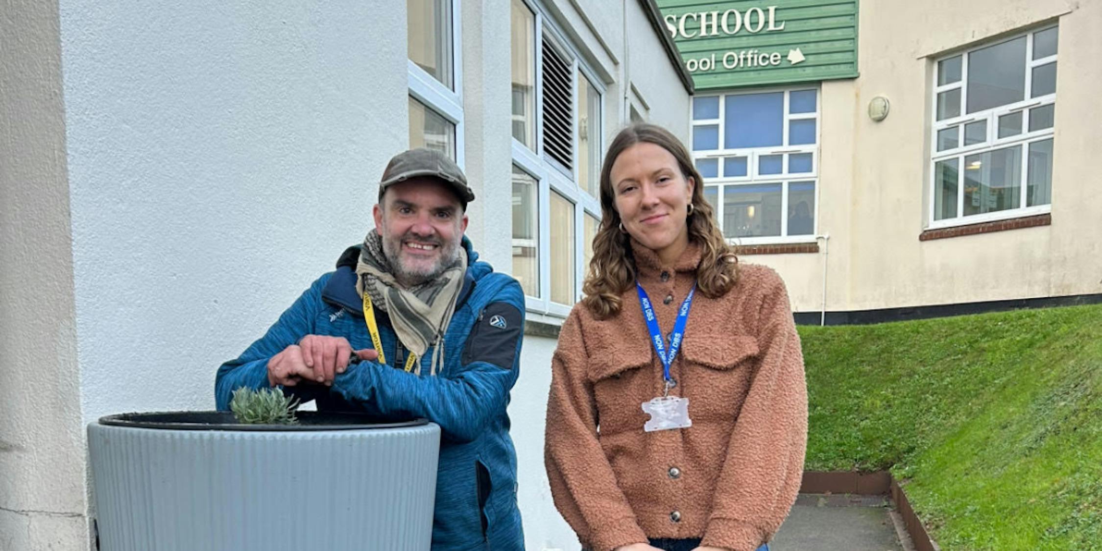 Laura and Nick standing next to a rainwater planter