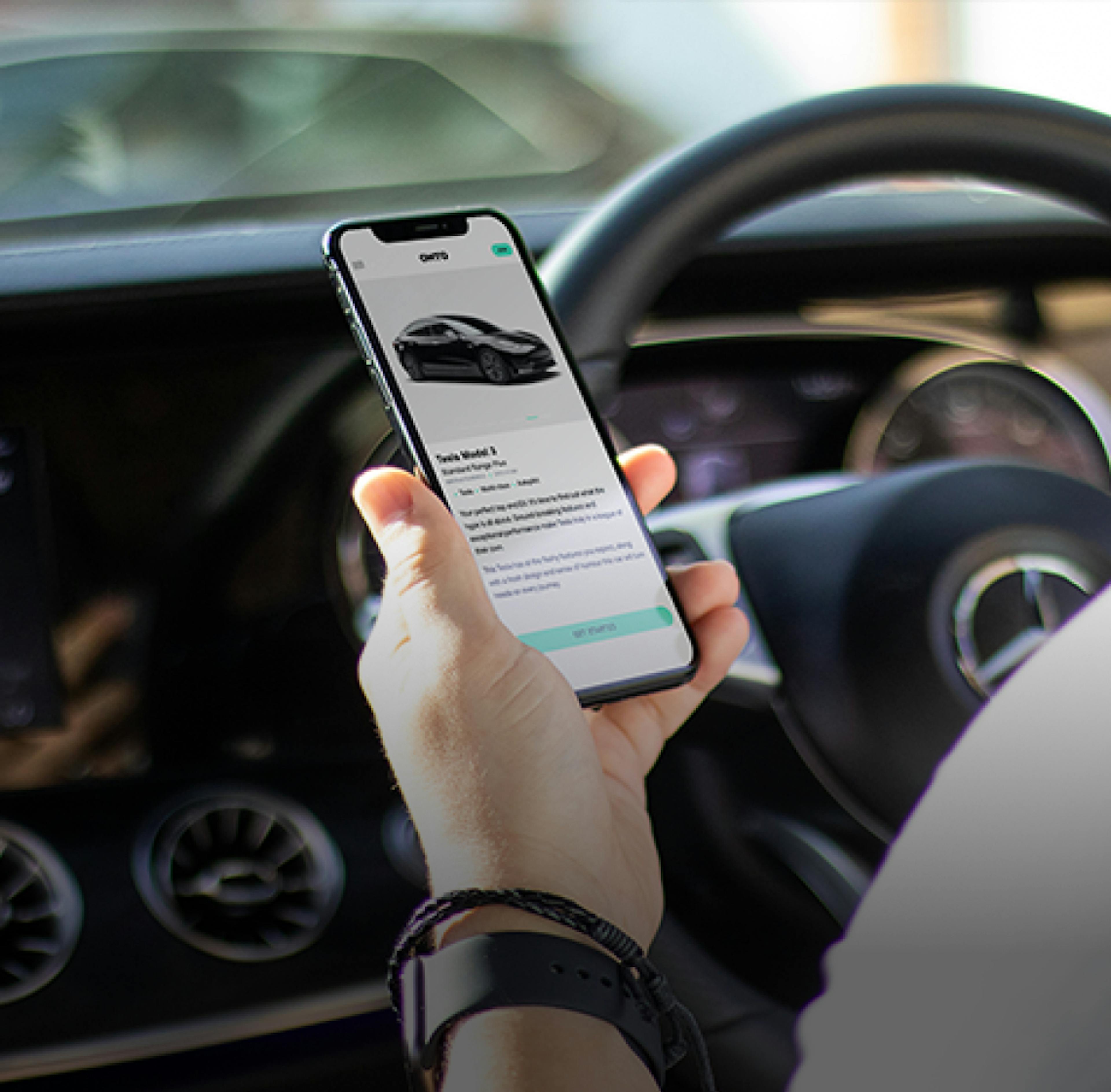 Person hält ein Telefon mit Onto-Anwendung in der Hand, während sie in einem Auto sitzt