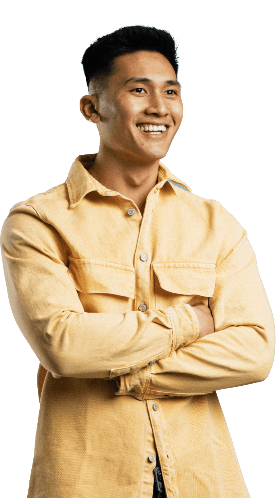 An Asian man in a yellow shirt smiles with his arms crossed.