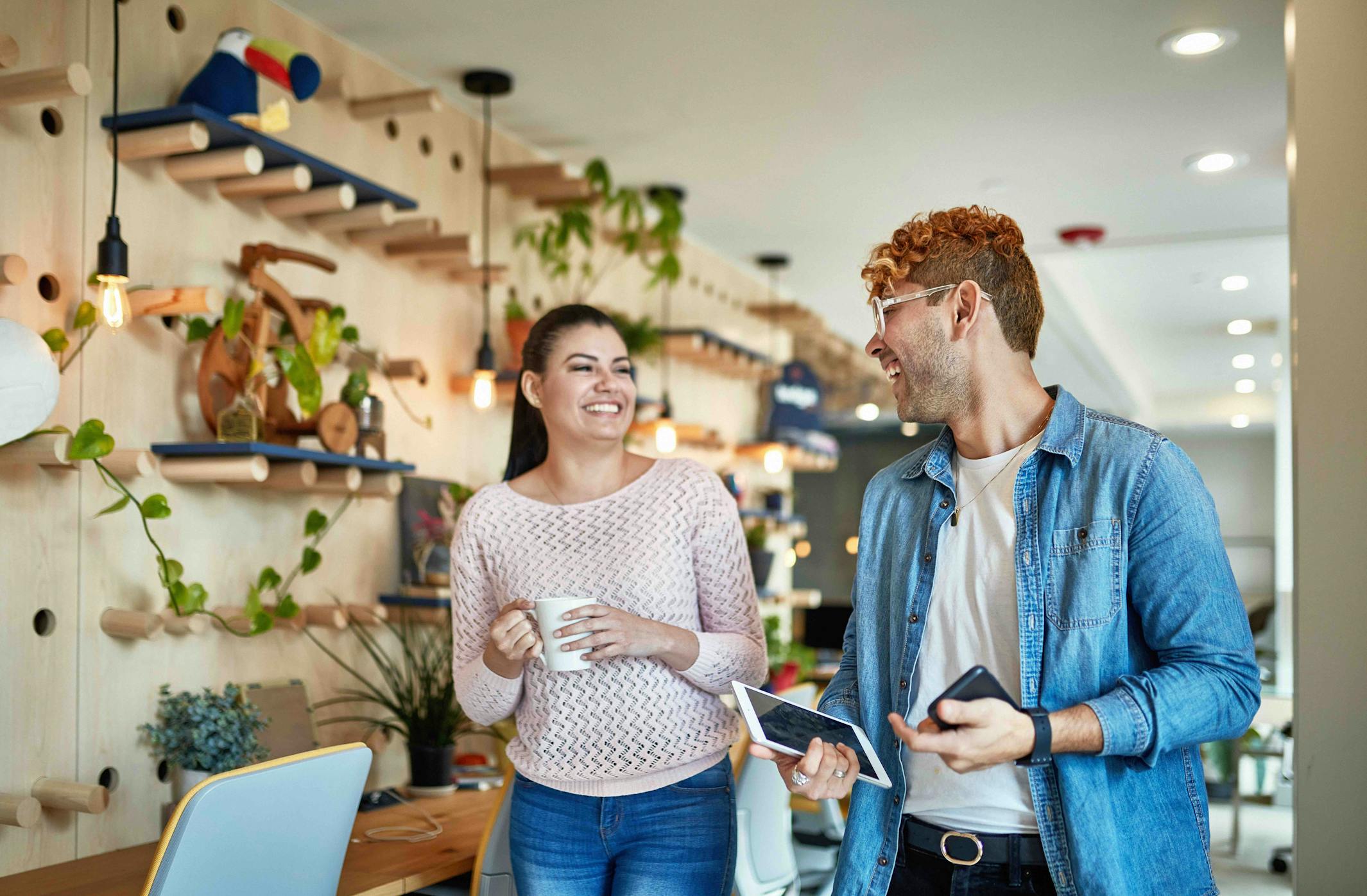 Two people talk in a warm, well-decorated office.