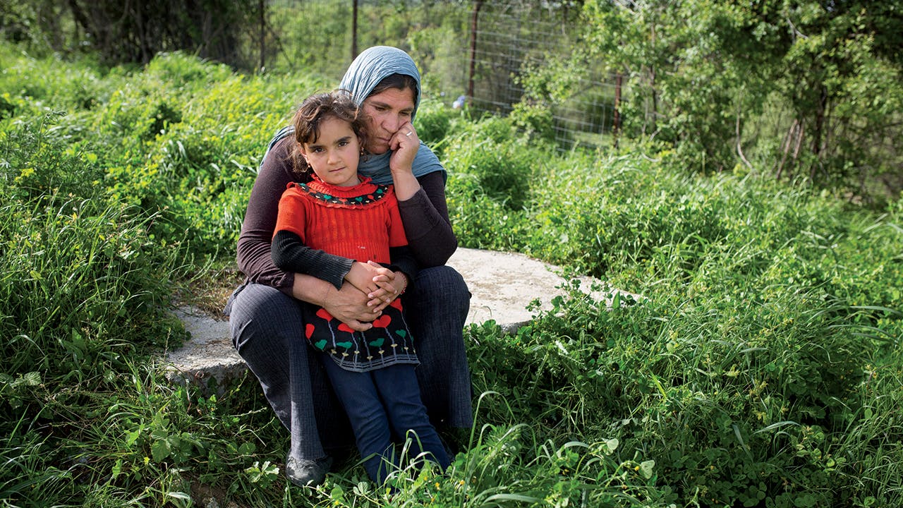 Nurfa, a Yazidi refugee woman, with her granddaughter, Julia, at Petra Camp in Greece, after escaping ISIS attacks on their homes and villages in Iraq. Many Yazidis were killed during the attacks, while others were captured and enslaved. The lucky ones made it to Europe, where they found themselves, along with tens of thousands of other asylum-seekers, stuck in Greece.