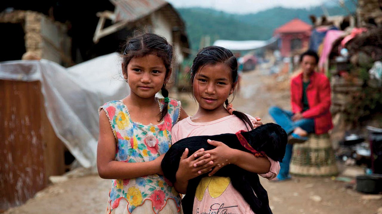 Girls with one of their surviving goats in Nepal's Lalitpur District, after the 2015 earthquake, which killed 9,000 people and countless animals, including  livestock; this created hardships for farmers and rural communities here, which depend on animals for food.