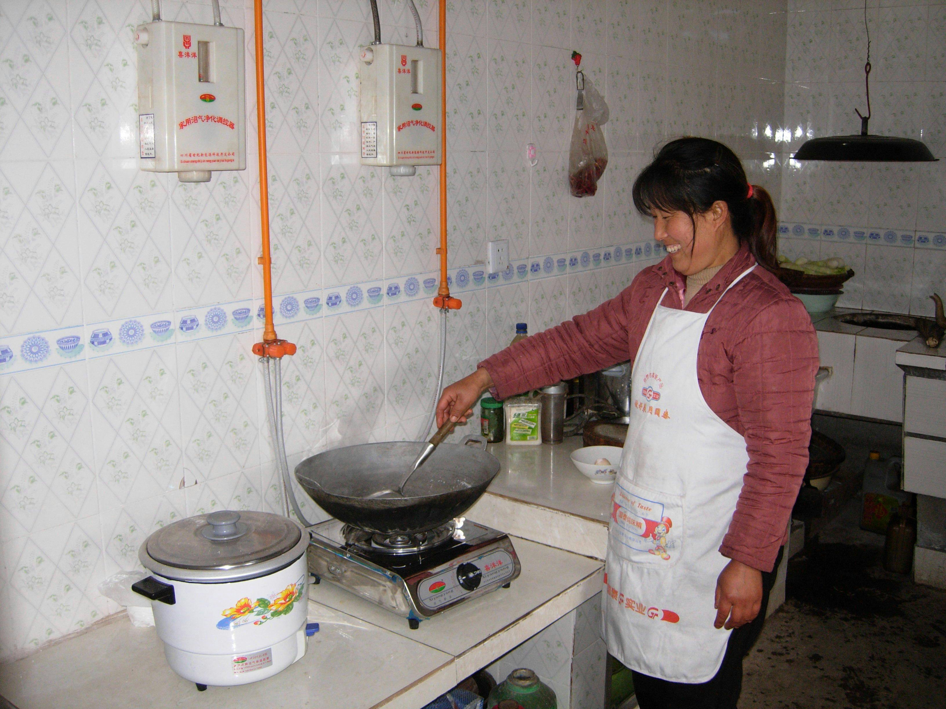 Kvinne lager mat med biogassanlegg i Kina