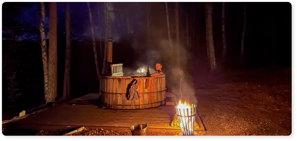 Romantisk vildmarksbad om aftenen hos Yggdrasil Igloo Värmland