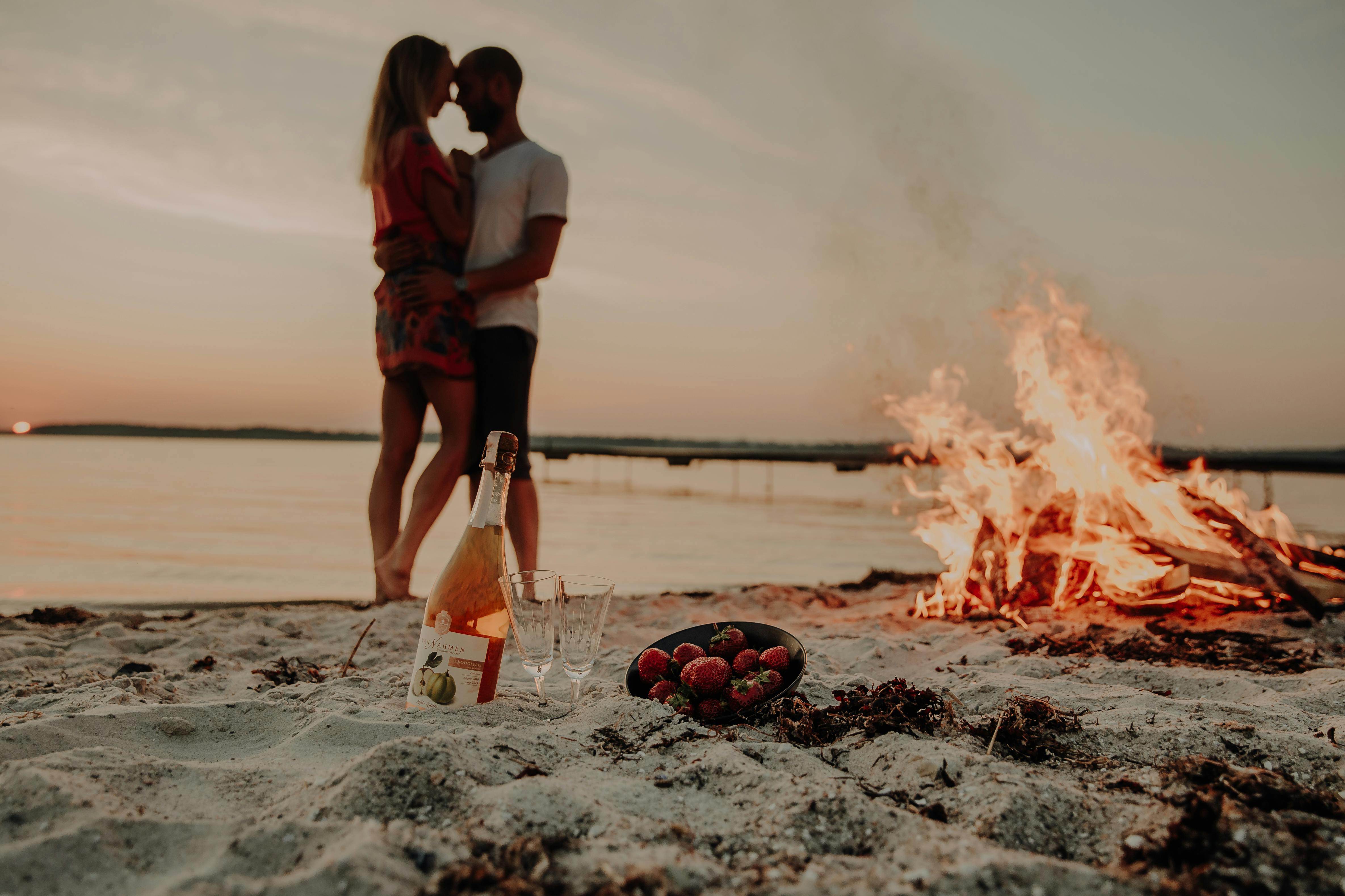 romantic couple on beach with bonfire