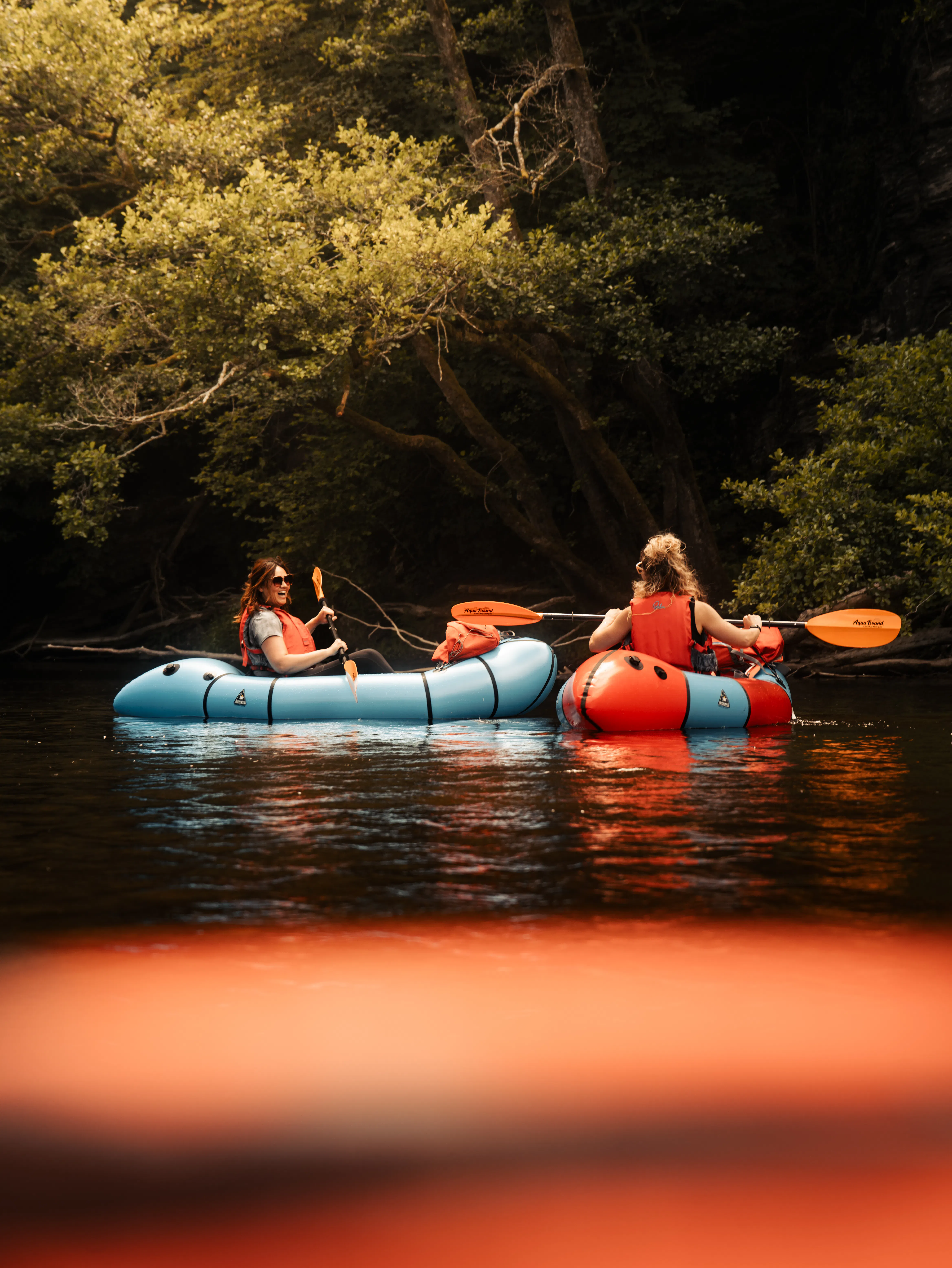 Packrafter met rugzak en packraft tijdens een wandelroute