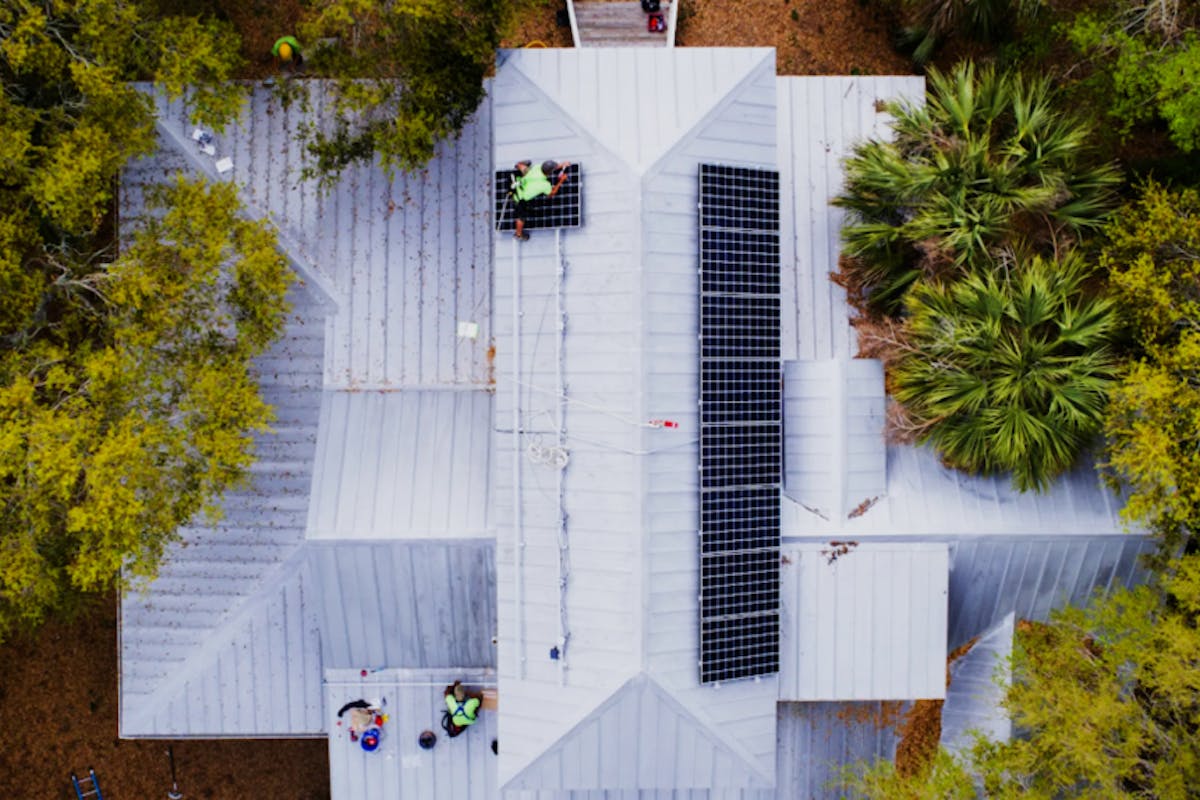 Overhead drone shot of a Palmetto solar power system being installed on a roof.