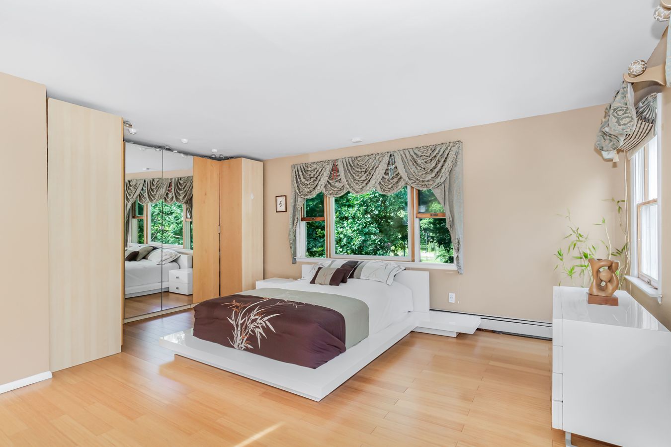 A bedroom with a baseboard heater.