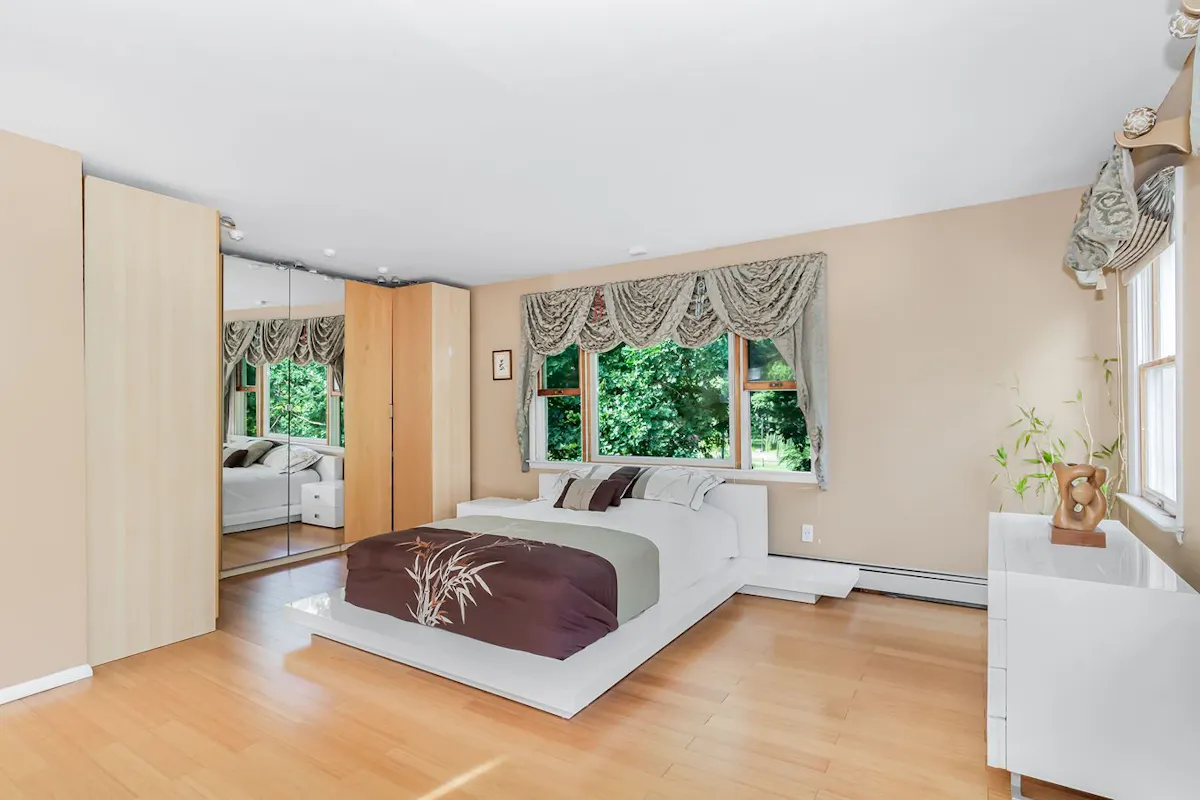 A bedroom with a baseboard heater.