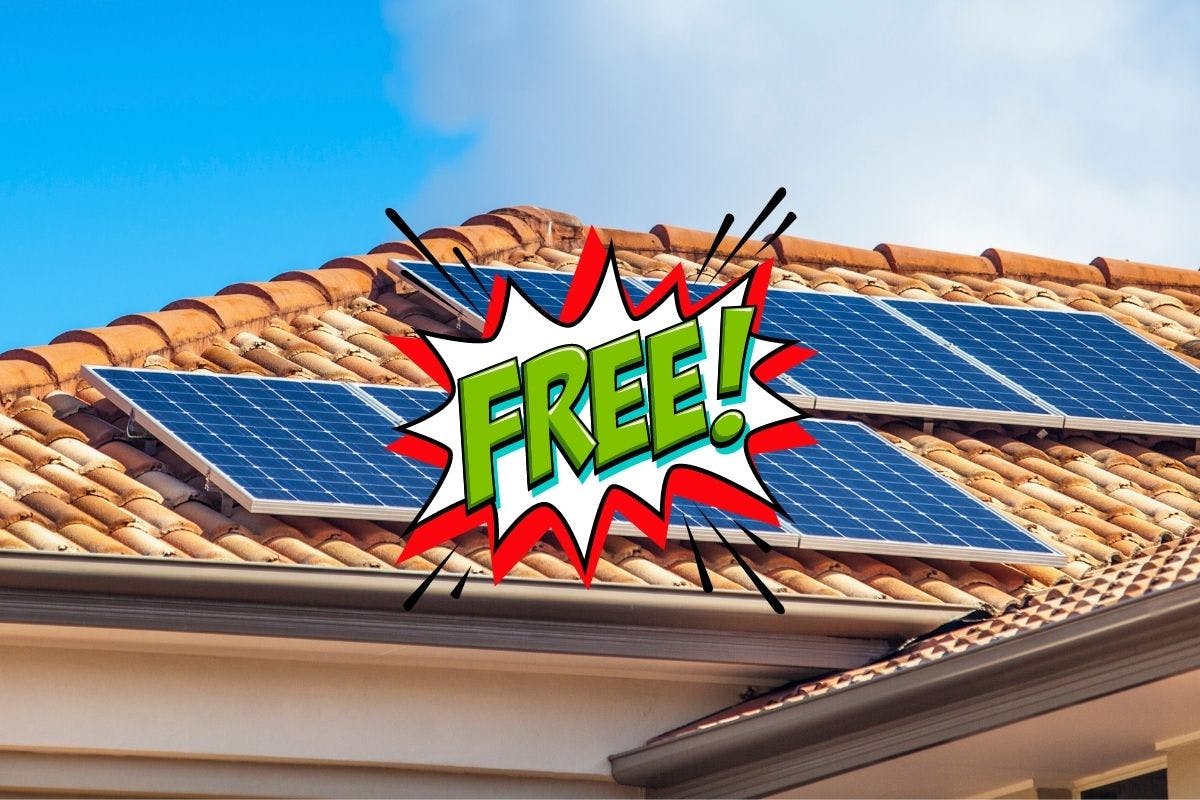 Solar panels on a tan roof made of ceramic tiles with "FREE!" in green text covering everything, showing how free solar panels are often advertised.