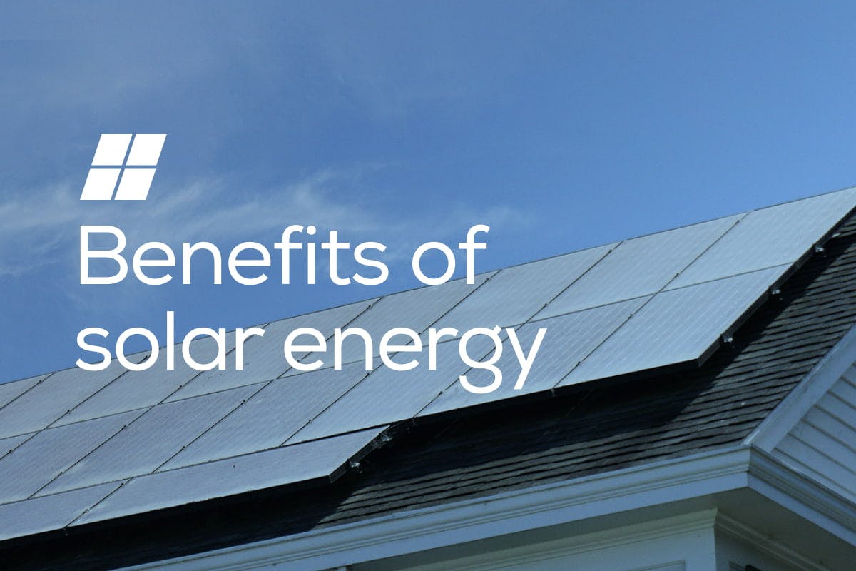 The words "Benefits of Solar Energy" on top of an image of a home's roof with solar panels sitting under a blue sky, helping to save money and lower the homeowner's electricity bill.
