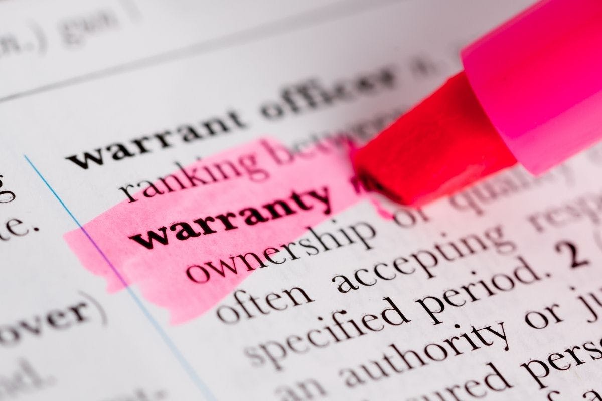 The word "warranty" on a dictionary page is highlighted in pink, while a pink highlighter sits to the right, during research on solar warranty options.