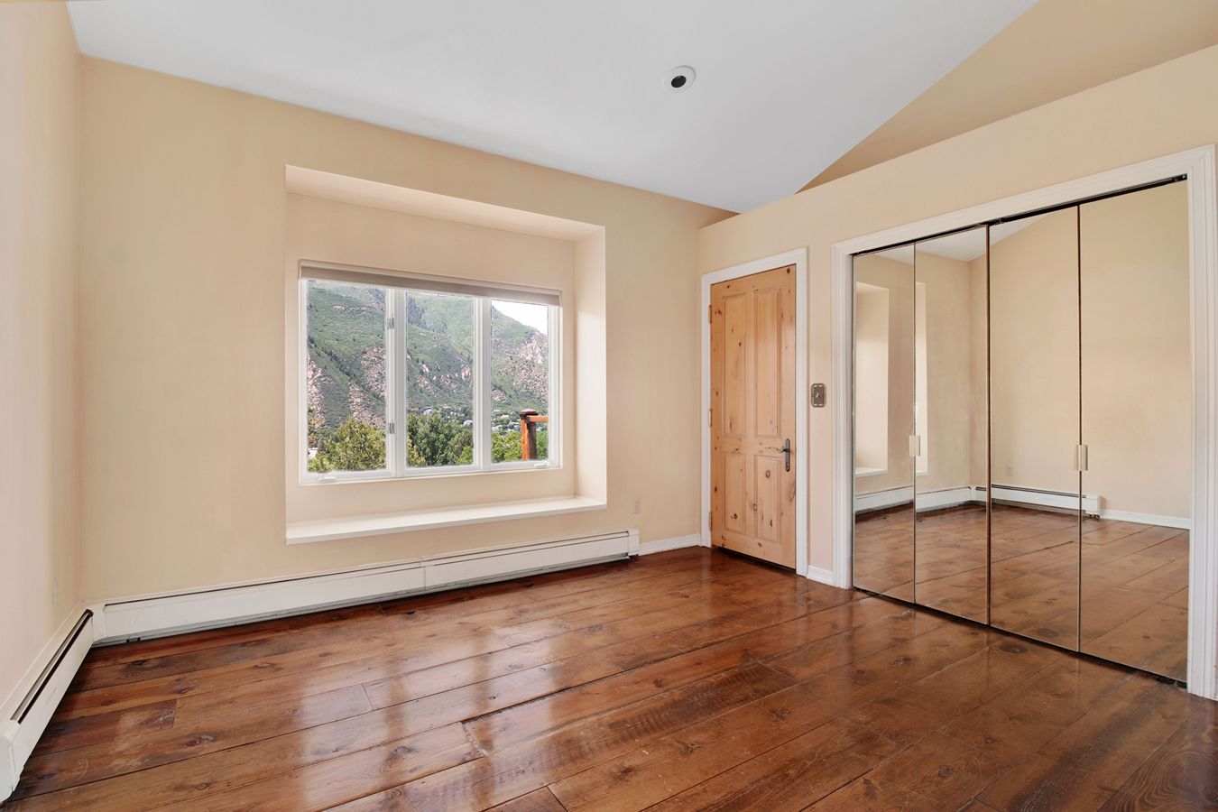 An empty room with floorboard heaters.
