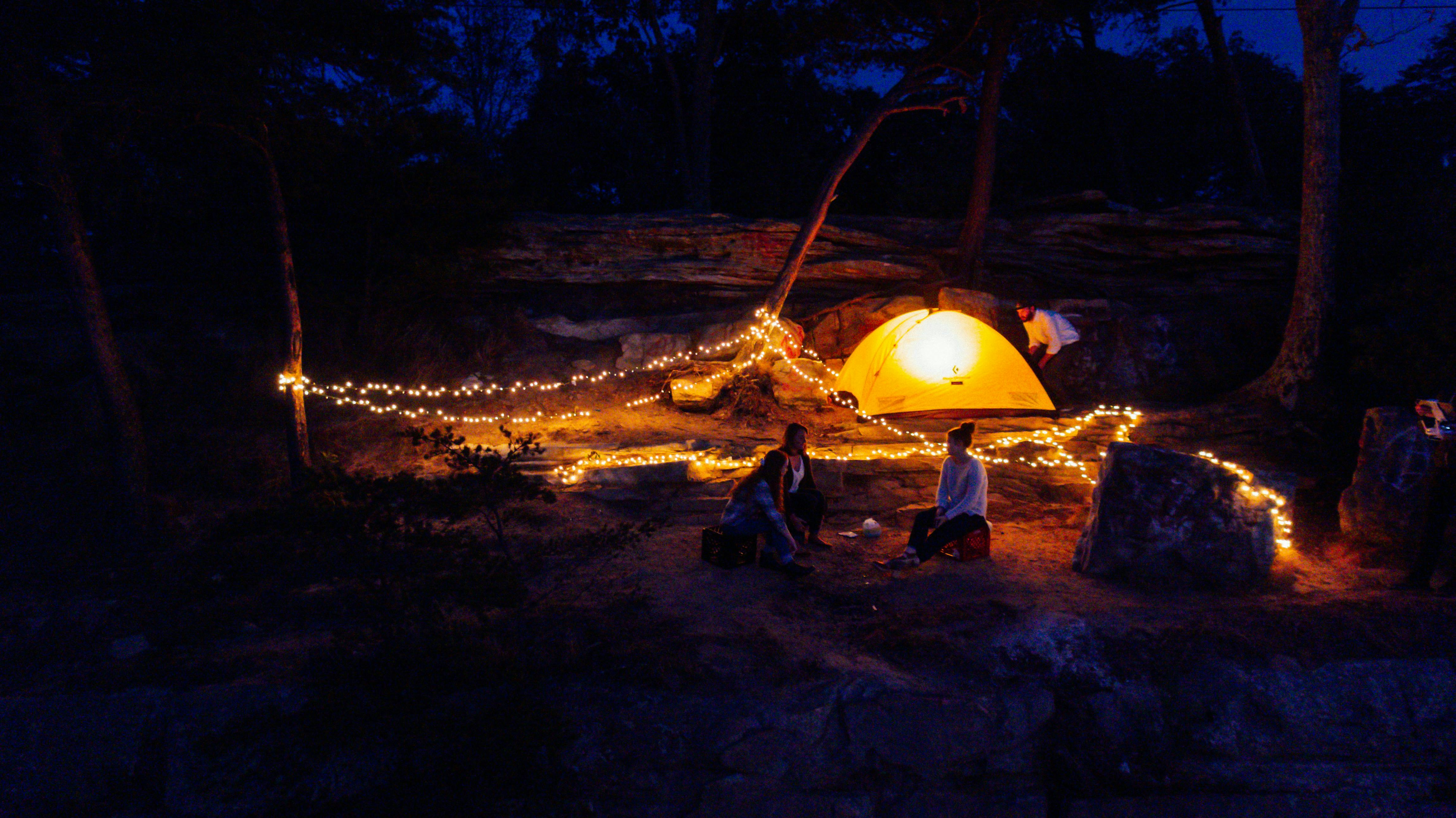 A tent and string lights lit up in the dark.