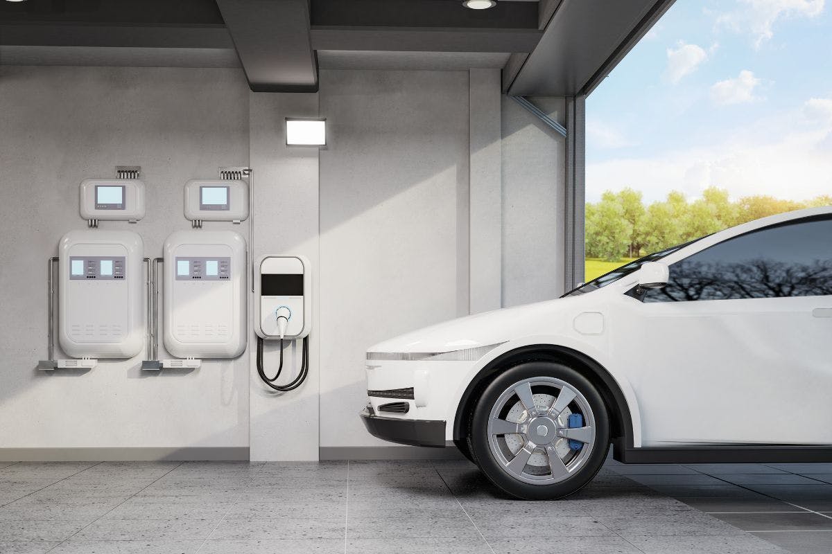 An electric vehicle, ev charger, and home batteries in a garage.