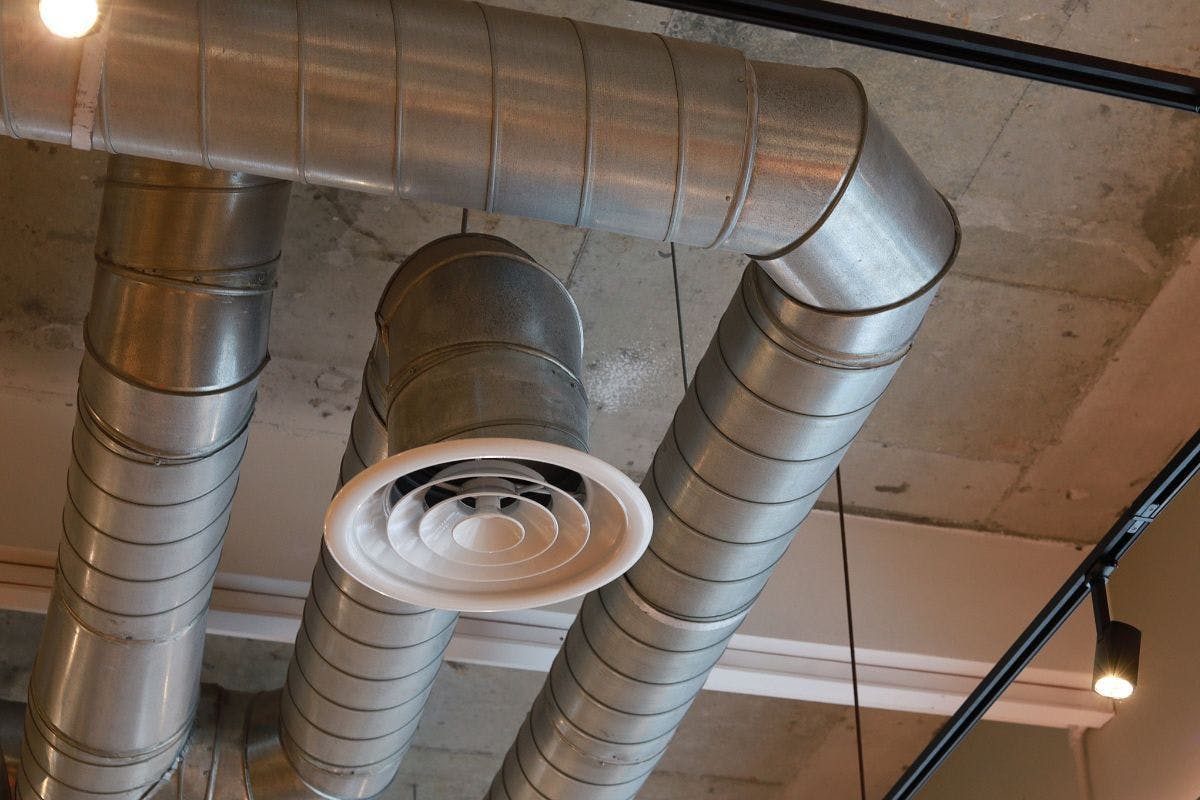 Ducts and vents against an exposed ceiling.