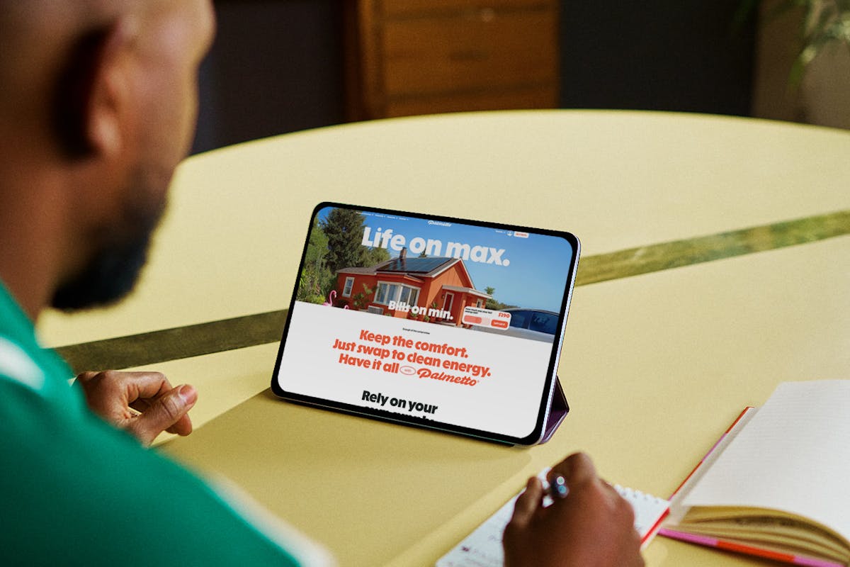 A person at a table looking at the rebranded Palmetto homepage on a tablet.