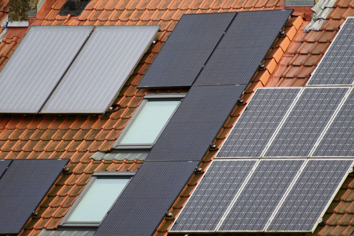 Black and blue solar panels on a tile roof.