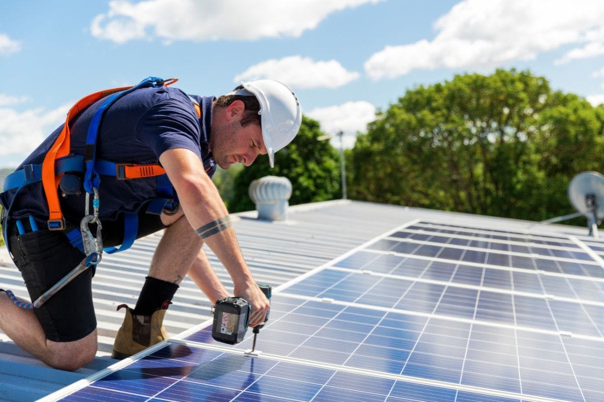 A solar installer attaching panels to a roof.