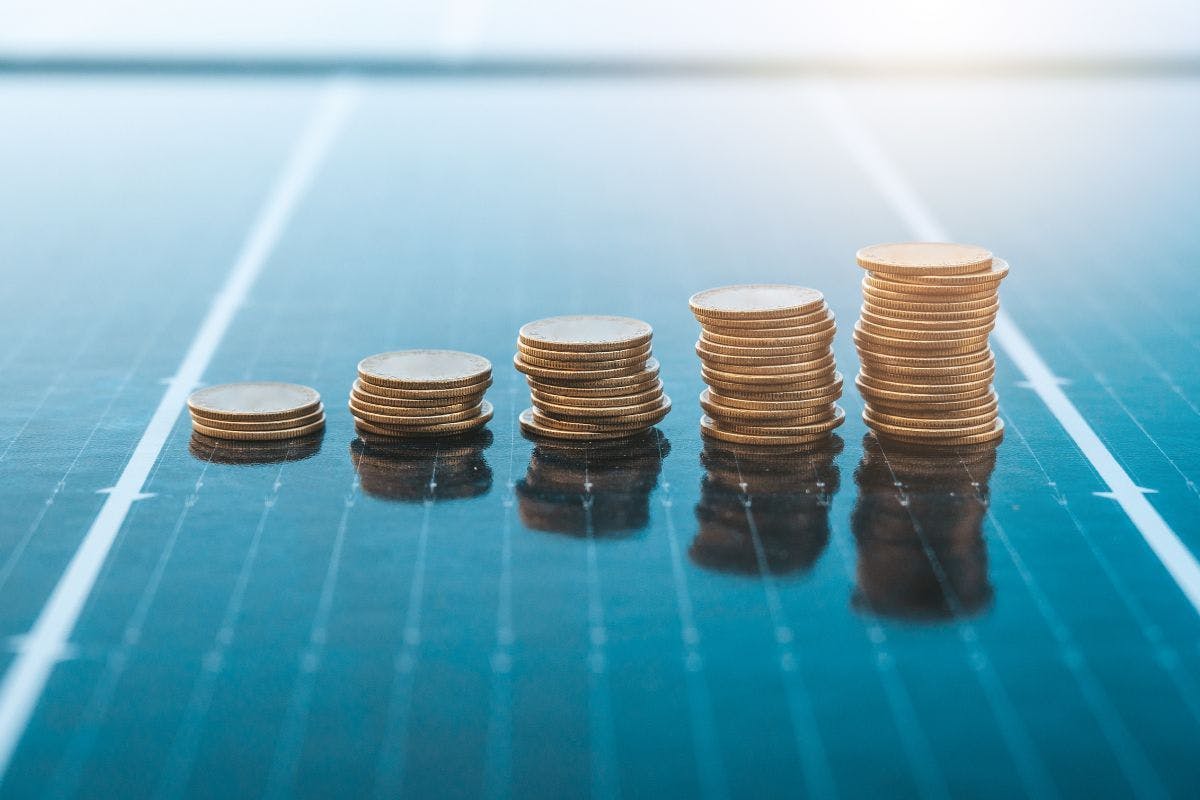 Stacks of coins increasing in size on a solar panel.