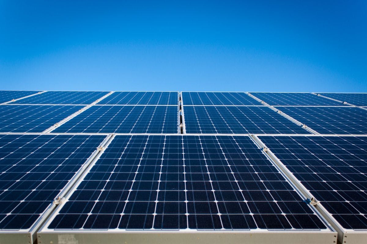 A close view of a solar panel array with a blue sky behind it.