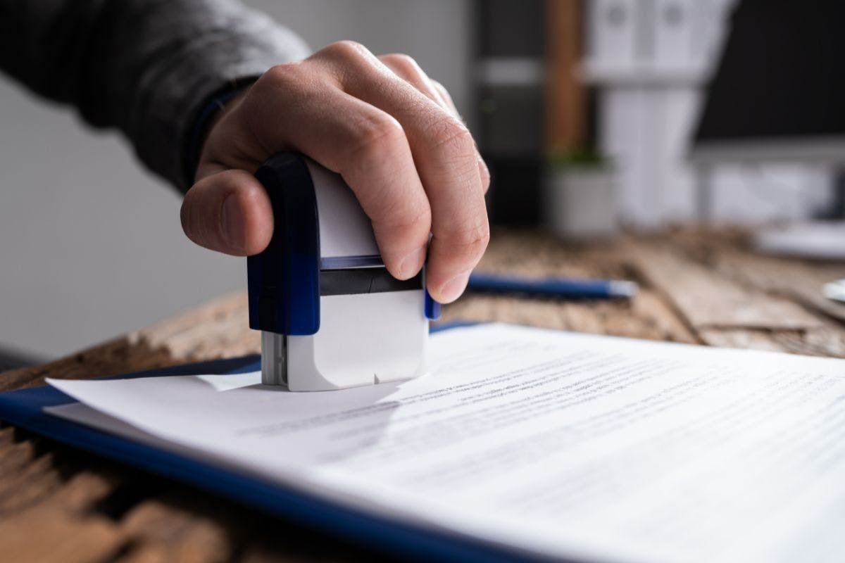 Someone stamping a document with their right hand.