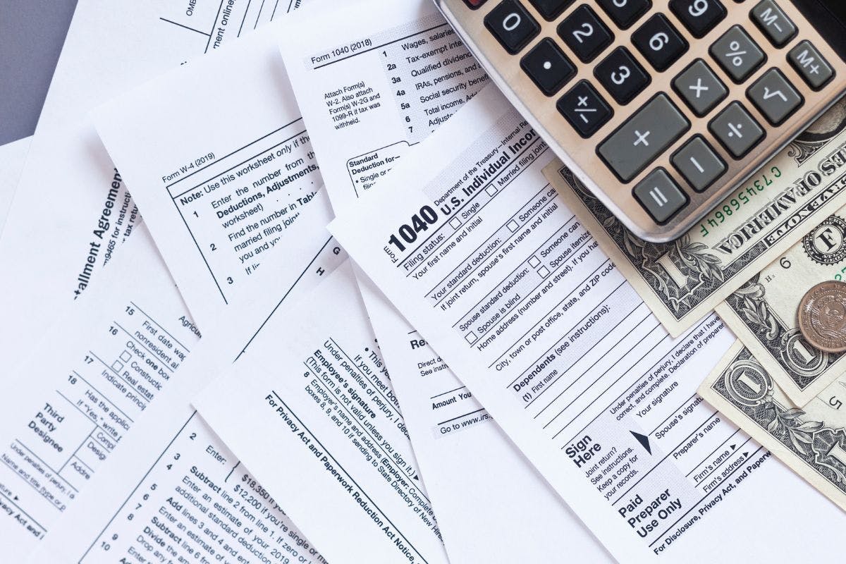 Tax documents, a calculator, and some American currency.