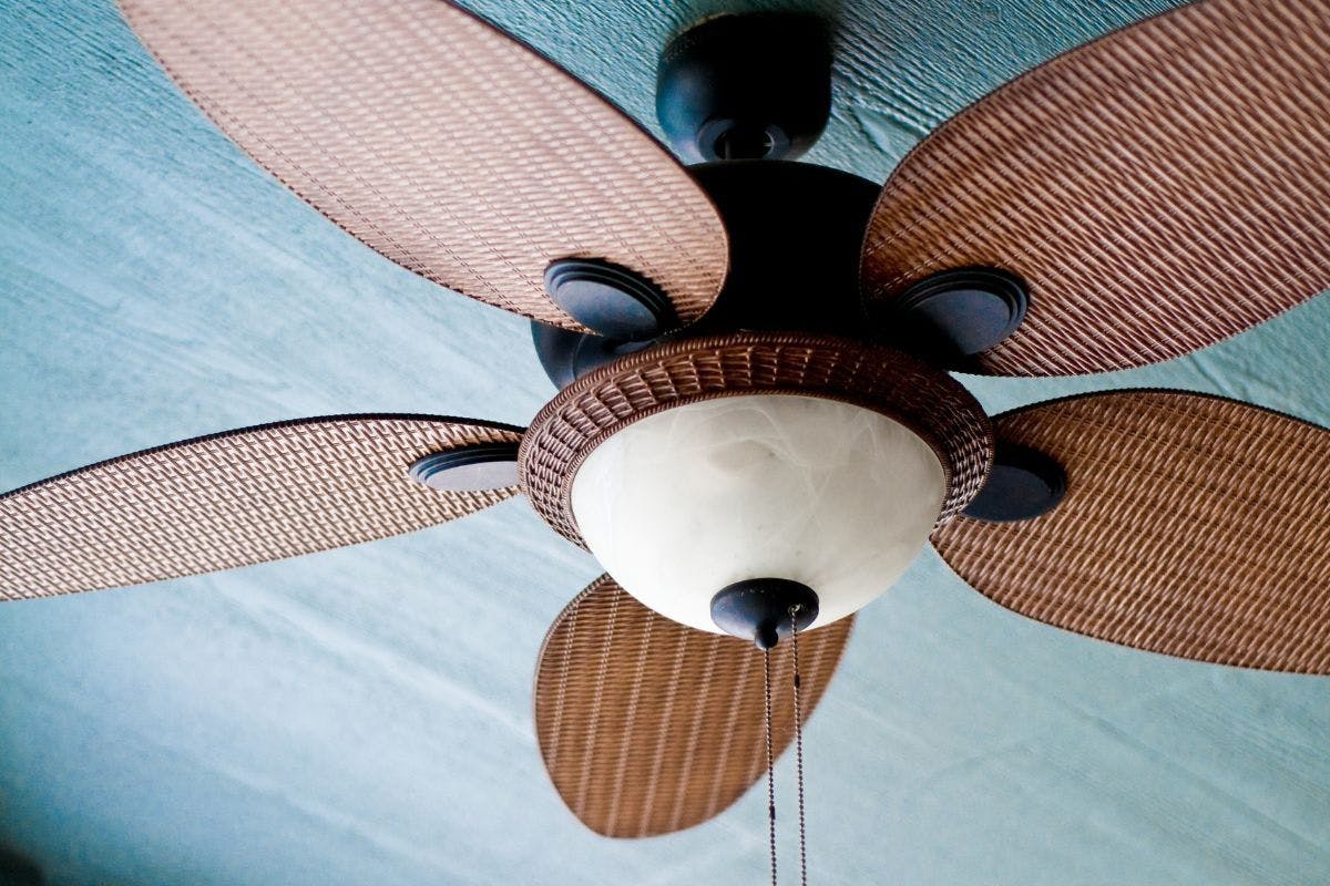 A wooden ceiling fan with a central light.