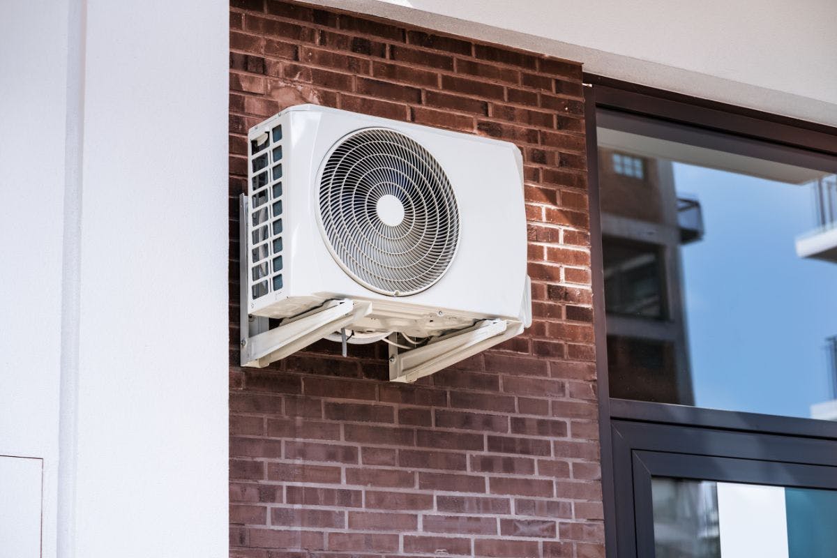 A heat pump mounted on an exterior wall.