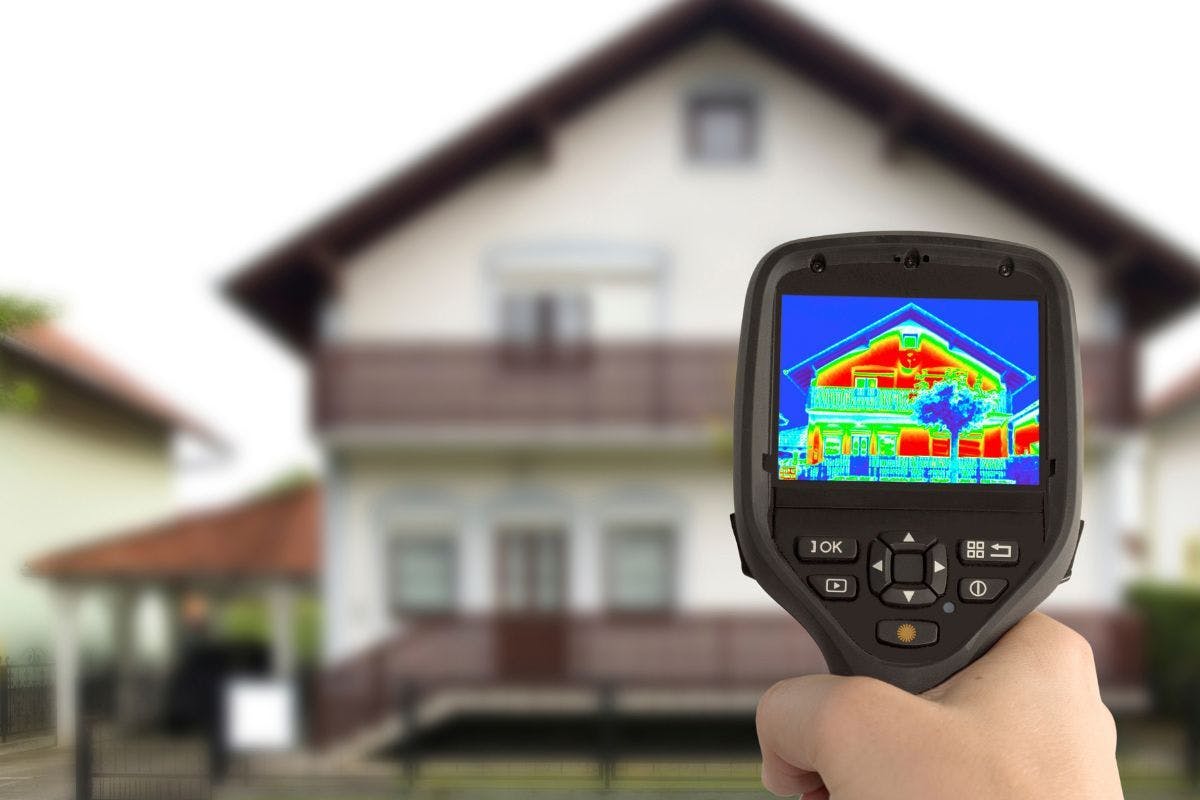 A thermal gun pointing at a two story home.