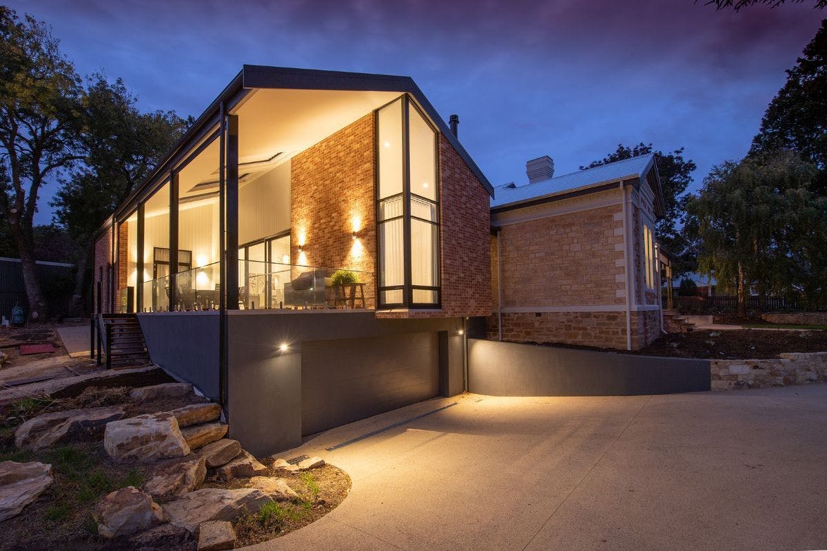 A house with the lights on while dark is around.