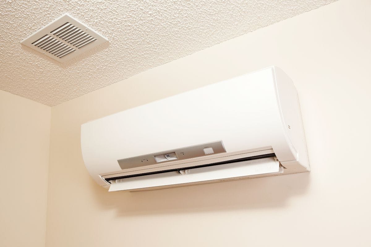 A mini split heat pump mounted on an interior wall.