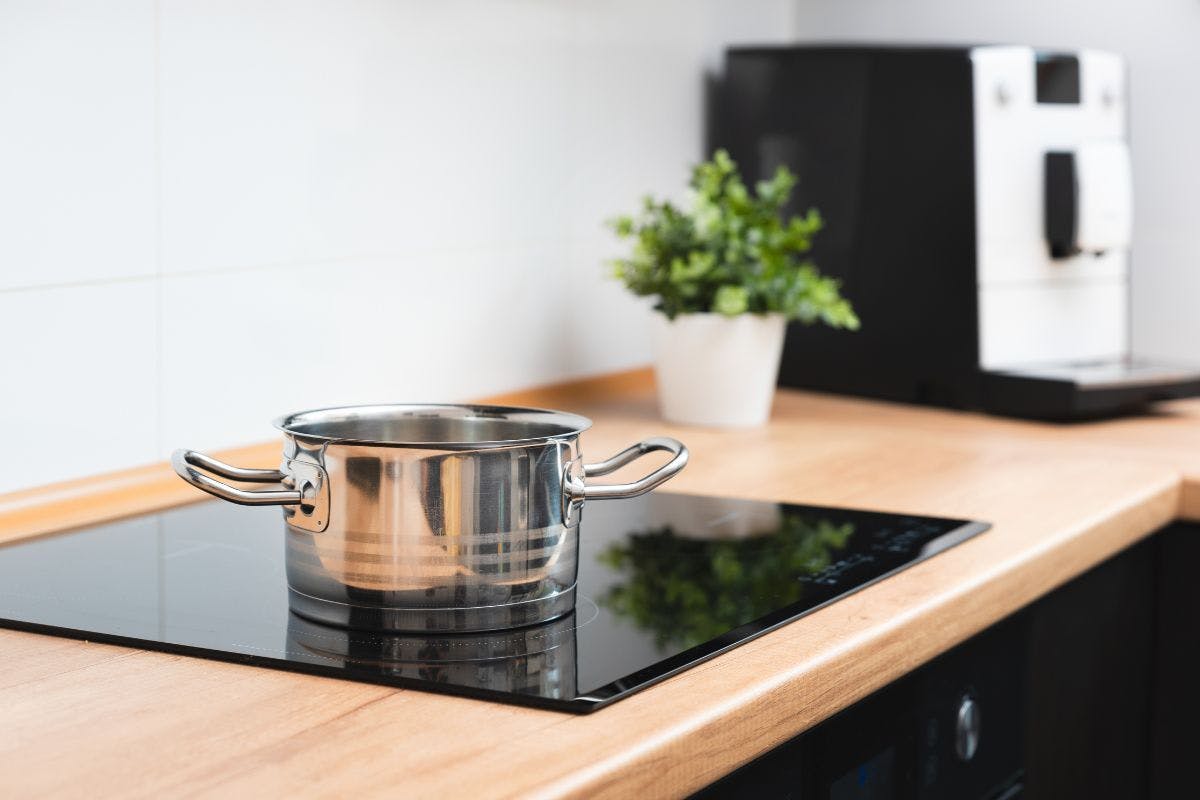 A pot sitting on an electric stove built into a wooden countertop.