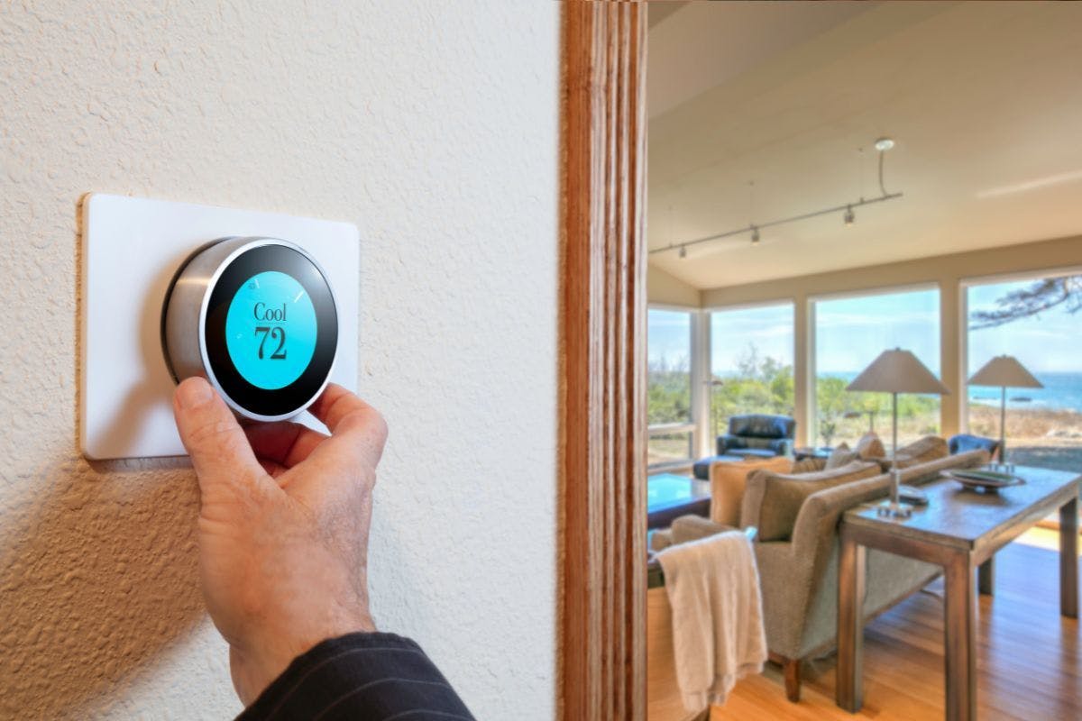 Adjusting a smart thermostat set to cool to 72 degrees.