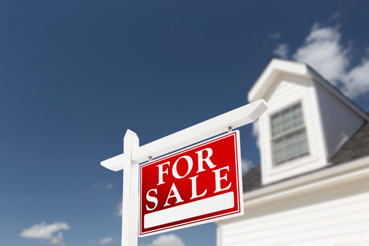 A for sale sign in front of a house.
