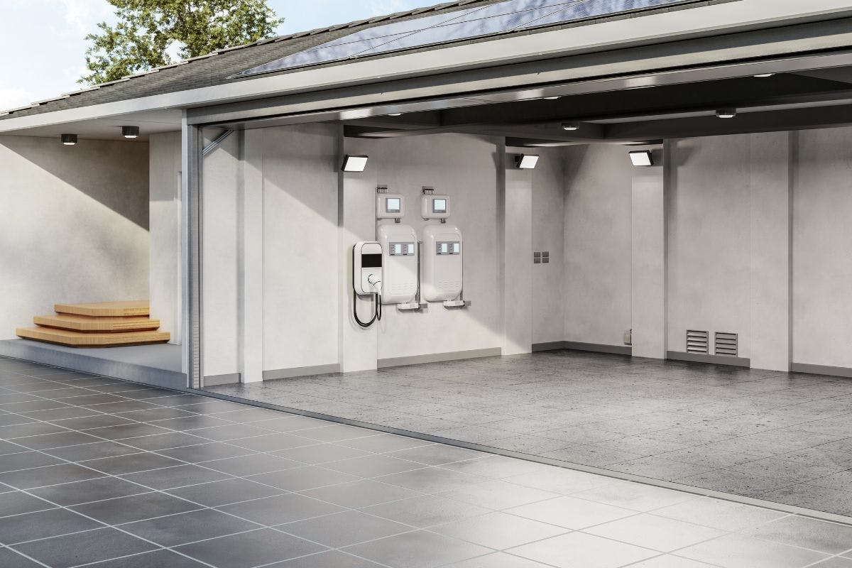 An open garage with an EV charger inside and solar panels on the roof.